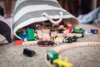 a bag of wooden toys by a train set