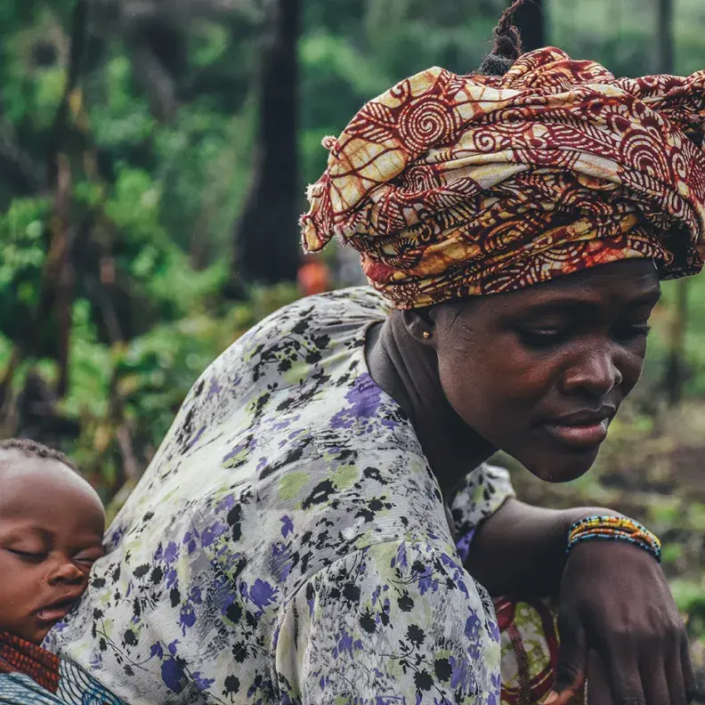 Image: baby on mothers back. Topic: Investing in Indigenous Communities